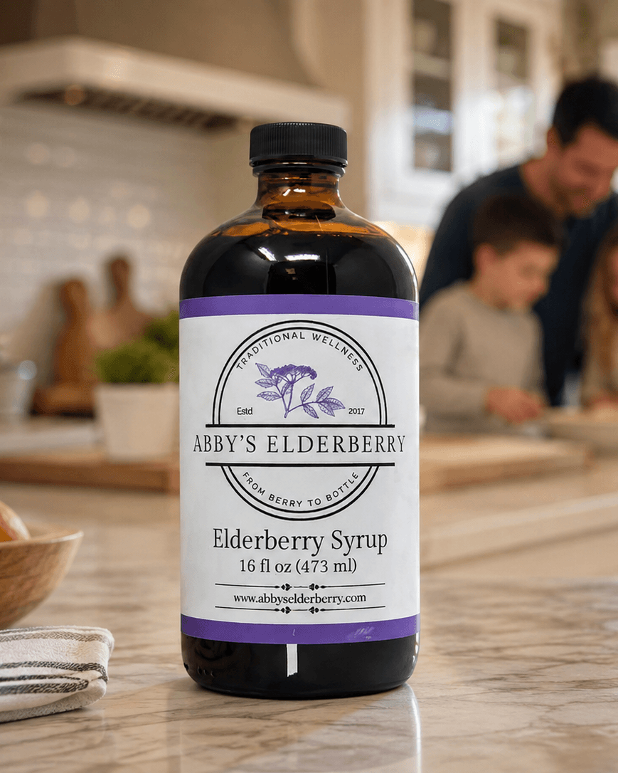 A bottle of Abby's Elderberry syrup on a kitchen counter, with a family cooking in the background